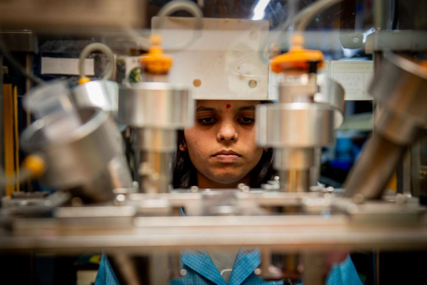 Close machinery detail with worker visible through equipment